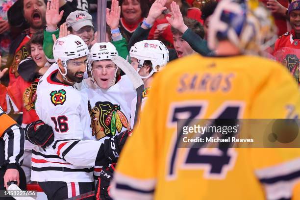 MacKenzie Entwistle of the Chicago Blackhawks celebrates with teammates after scoring a goal against the Nashville Predators during the second period...