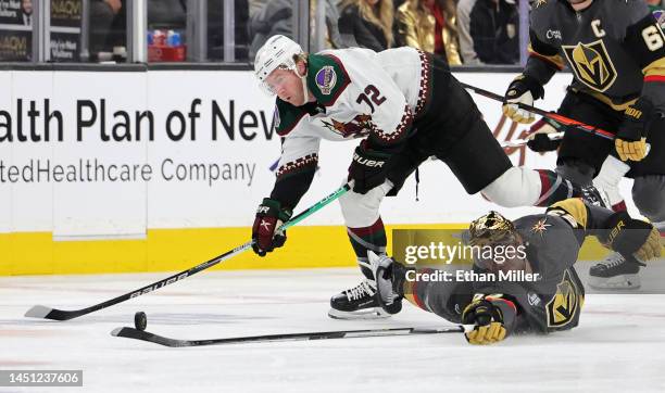 Travis Boyd of the Arizona Coyotes and Alec Martinez of the Vegas Golden Knights vie for the puck in the first period of their game at T-Mobile Arena...