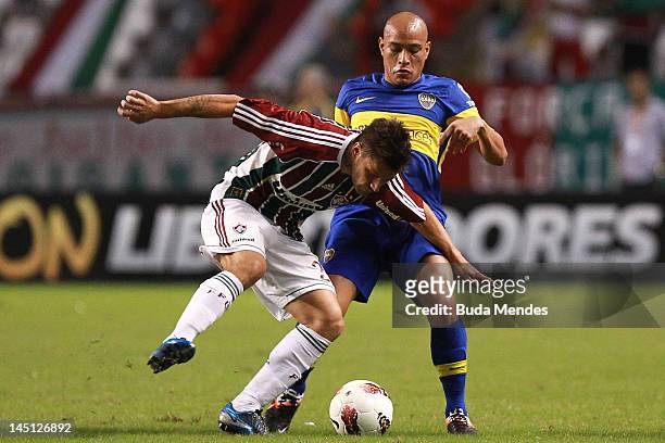 Rafael Sobis of Fluminense struggle for the ball with Clemente Rodriguez of Boca Juniors during a match between Fluminense and Boca Juniors as part...