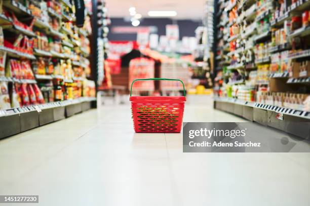 grocery store, shopping basket or container on floor and food product, cooking ingredients or household sales goods. supermarket, retail store or plastic carrier object for commercial consumer buying - market retail space stockfoto's en -beelden