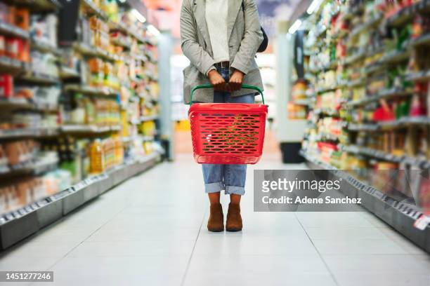 supermarket aisle, woman legs and basket for shopping in grocery store. customer, organic grocery shopping and healthy food on groceries sale shelf or eco friendly retail purchase in health shop - shopping basket bildbanksfoton och bilder