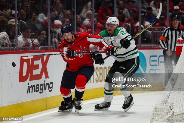 Nick Jensen of the Washington Capitals and Roope Hintz of the Dallas Stars vie for the puck during the third period of the game at Capital One Arena...