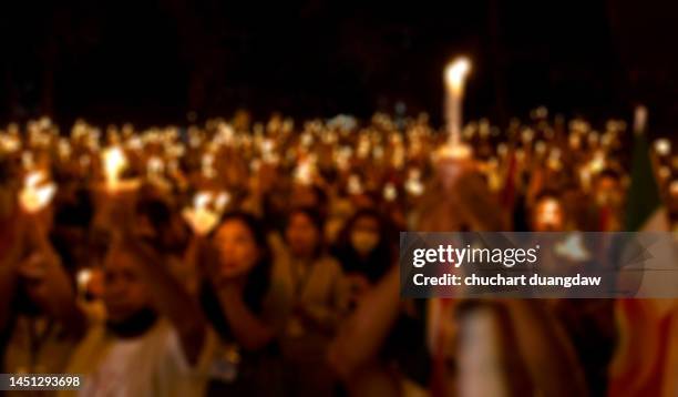 defocused background of people lighting candles for celebrations in thailand - memorial vigil ストックフォトと画像