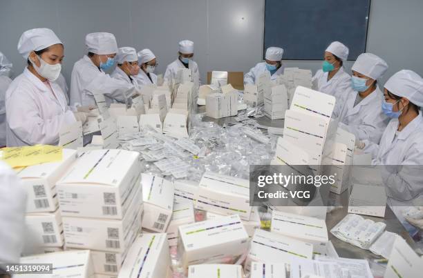 Employees work on the packaging line of COVID-19 rapid antigen test kits at a pharmaceutical company on December 21, 2022 in Haikou, Hainan Province...