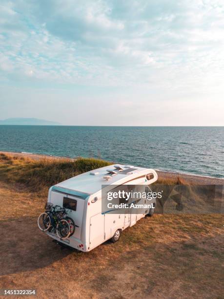 aerial view of motor homes on the beach at sunset in kanali, greece - camper stockfoto's en -beelden
