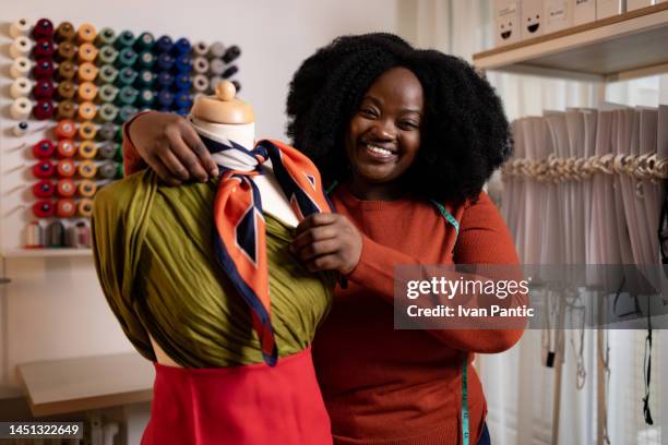 happy african american female tailor working on mannequin in clothing studio. - fashion designer stock pictures, royalty-free photos & images