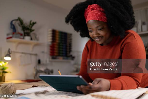smiling black designer using touchpad in a fashion studio. - touchpad bildbanksfoton och bilder