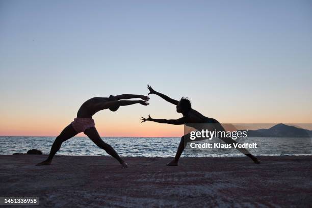 flexible woman and man dancing on pier together - bending over backwards stock pictures, royalty-free photos & images