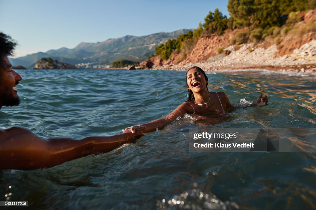 Woman swimming with boyfriend in sea