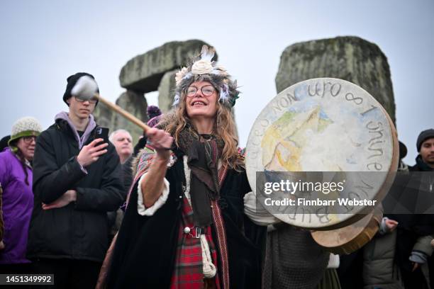 Woman plays the drum as people greet the sunrise at Stonehenge, on December 22 in Amesbury, United Kingdom. The famous historic stone circle, a...