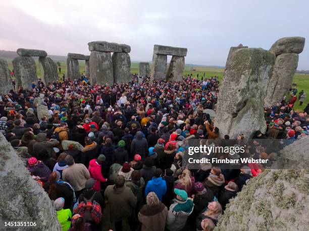 People greet the sunrise at Stonehenge, on December 22 in Amesbury, United Kingdom. The famous historic stone circle, a UNESCO listed ancient...