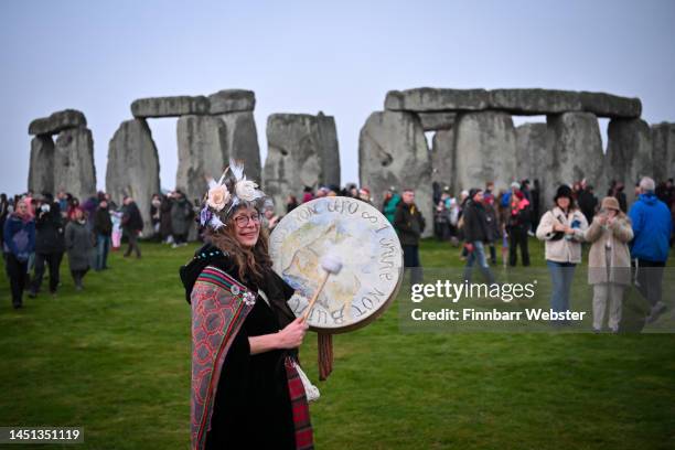 Woman plays the drum as people greet the sunrise at Stonehenge, on December 22 in Amesbury, United Kingdom. The famous historic stone circle, a...