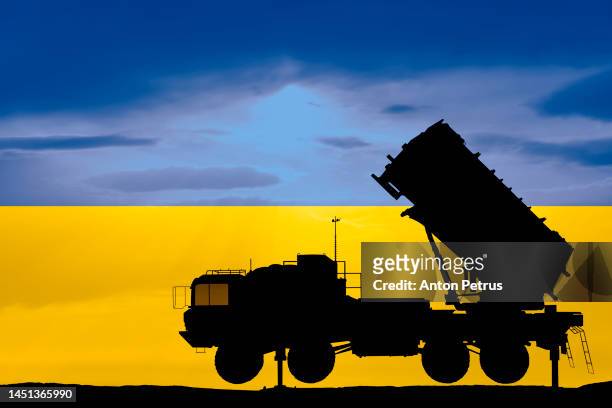 surface-to-air defense missile system on the background of the ukrainian flag - sam stock-fotos und bilder