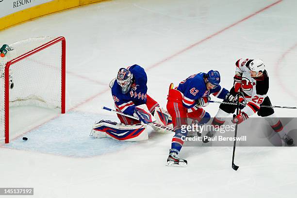 Patrik Elias of the New Jersey Devils scores a first period goal past Artem Anisimov and Henrik Lundqvist of the New York Rangers in Game Five of the...