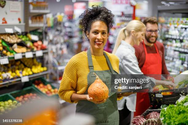 portrait of a sales clerk in a organic grocery store - greengrocer's shop stock pictures, royalty-free photos & images