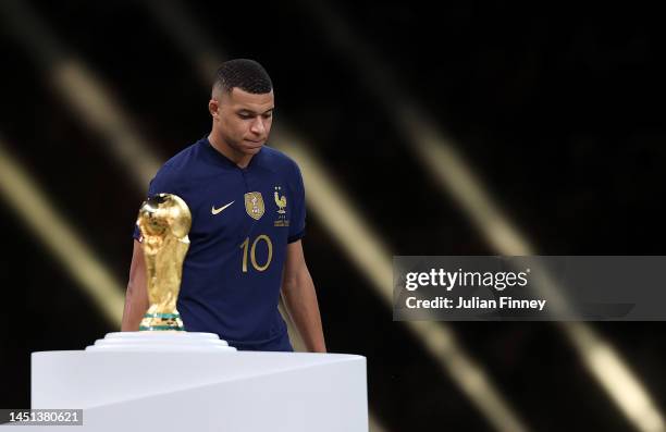 Kylian Mbappe of France walks past the FIFA World Cup trophy as he looks dejected following his teams loss in the FIFA World Cup Qatar 2022 Final...