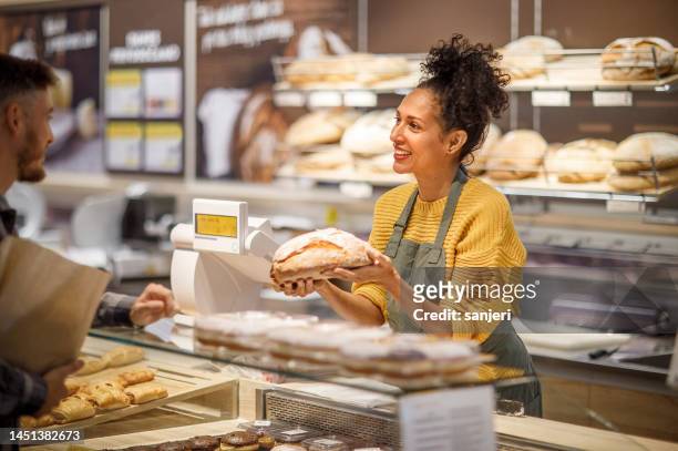 empleado minorista que atiende a un cliente - bakery fotografías e imágenes de stock