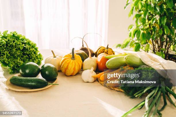 various vegetables lie on a white table. healthy food concept. sunny day. - fall harvest table stock pictures, royalty-free photos & images