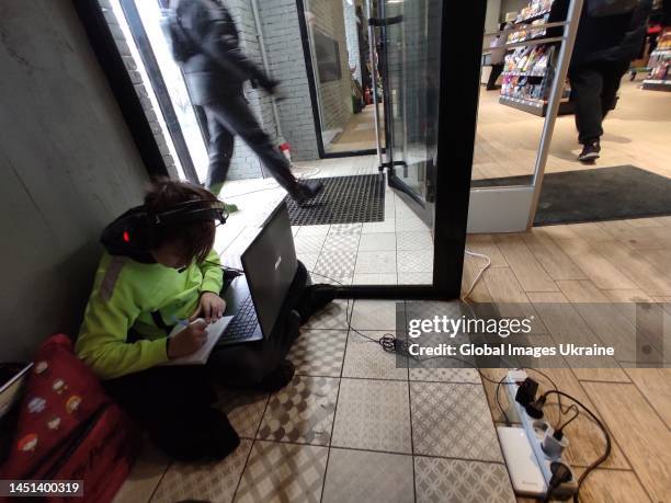 Boy takes notes during an online lesson in a store of Rozetka online retailer on December 21, 2022 in Kyiv, Ukraine. Some small businesses in Kyiv...