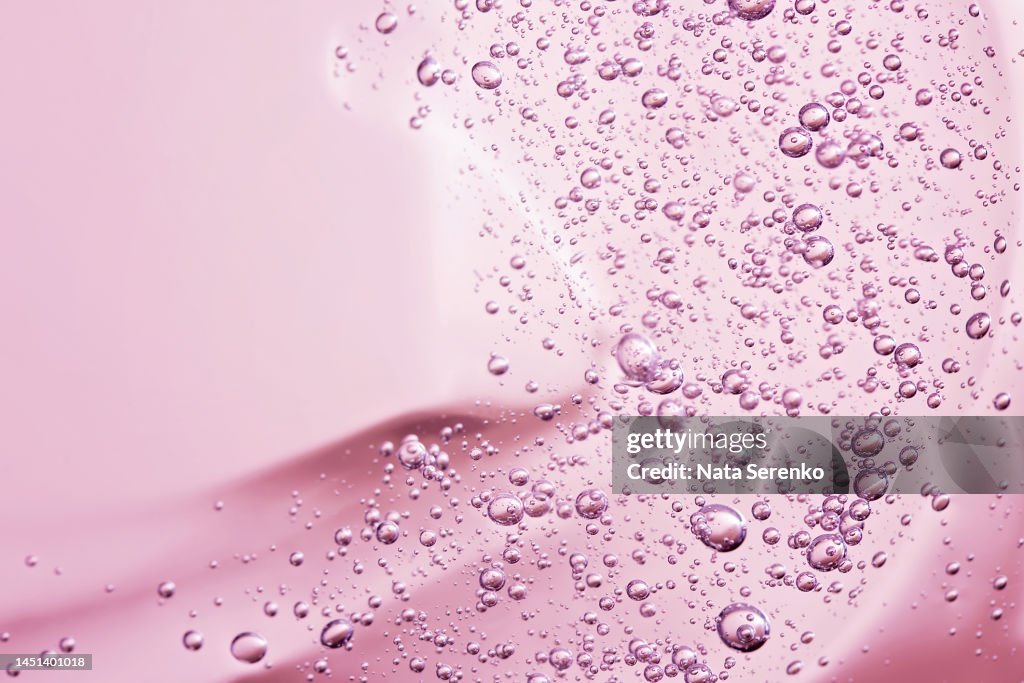 Close up macro Aloe vera gel cosmetic texture pink background.
