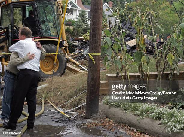 .EastonMA)A man who lived next door gets a hug with the scene of the house explosion on Seaver St in Easton in the background..