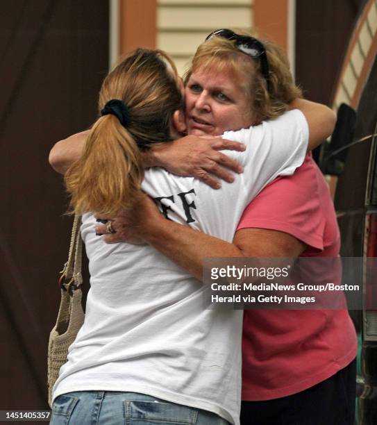 .EastonMA)A woman who lived next door gets a hug with the scene of the house explosion on Seaver St in Easton in the background..