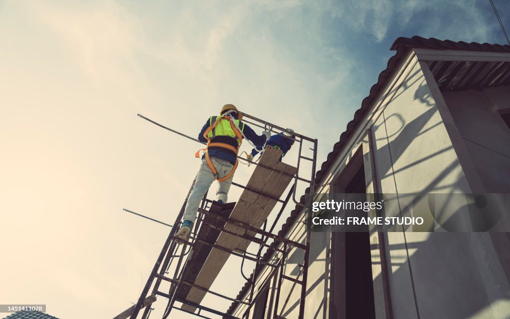 Workers, contractors, engineers in plaid shirts and yellow hard hats carry toolboxes. Inside the house that is being constructed, renovated, renovated by a professional technician who is ready to repair and improve And build a house according to the needs