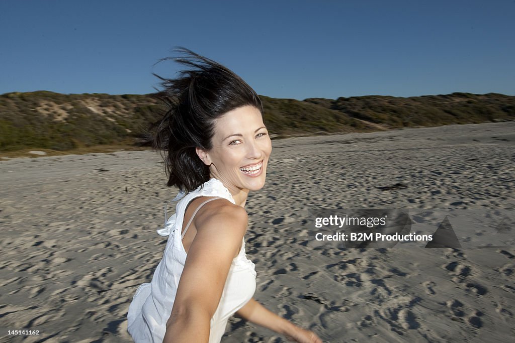 Happy young woman running on a beach