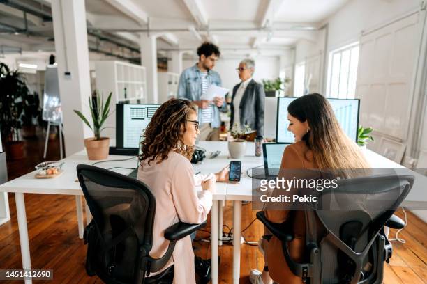 krypto-experten arbeiten im büro zusammen - businesswoman talking smartphone stock-fotos und bilder