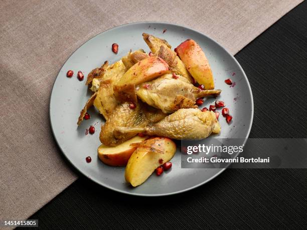 guinea fowl with apples and pomegranate - guineafowl stock-fotos und bilder