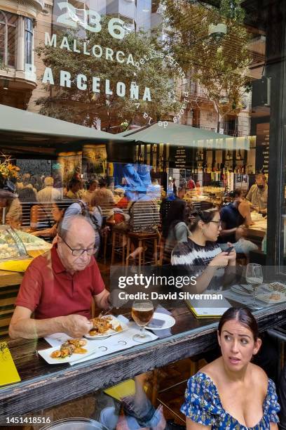 Woman waits for a table at the famous Cerveceria Catalana restaurant on September 7, 2022 in Barcelona, the capital and largest city of the...