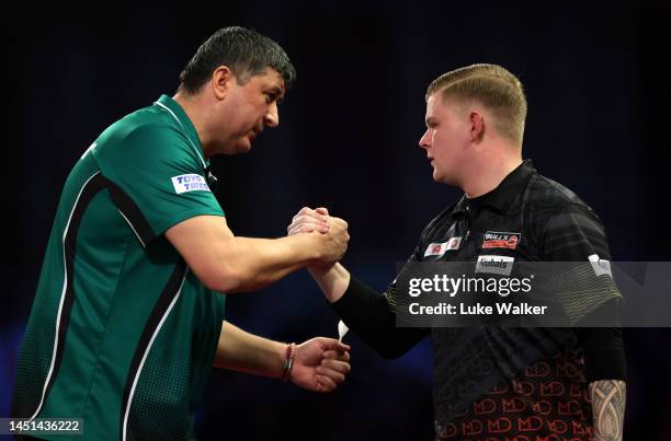 Mensur Suljović of Serbia and Mike De Decker of Belgium shake hands after their Round Two Match During Day Eight of The Cazoo World Darts...