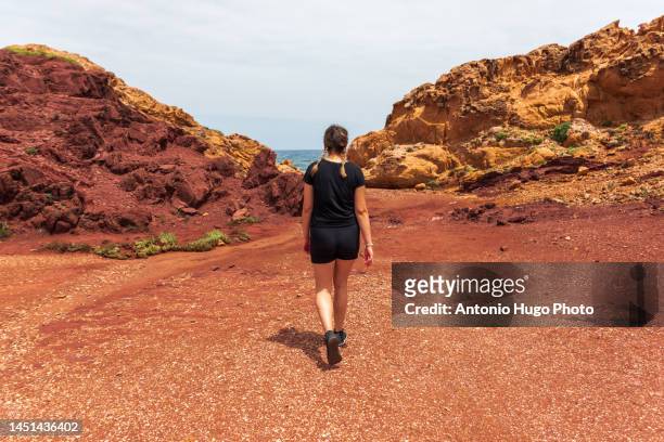 young woman with braids hiking through a volcanic landscape on the island of menorca. - biosphere planet earth bildbanksfoton och bilder