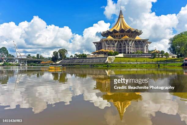 the sarawak legislative assembly complex and reflections in the sarawak river in kuching, sarawak, malaysia - kuching stock pictures, royalty-free photos & images