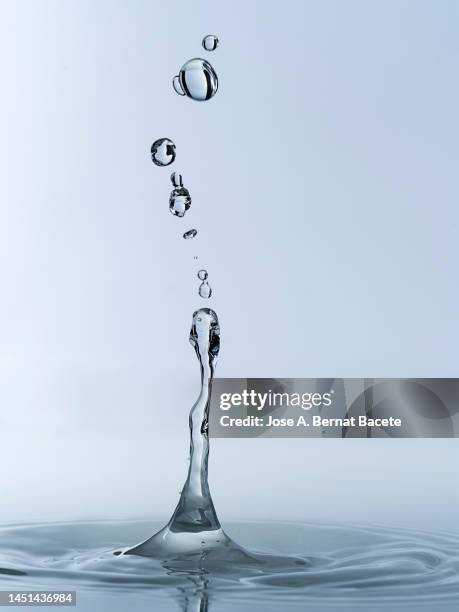 group of water droplets fall and bounce on a water surface. - regendruppel stockfoto's en -beelden