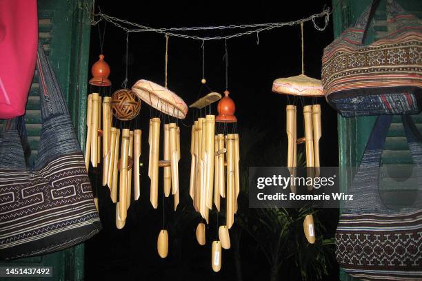 bamboo wind chimes dangling in the night. - wind chime stock pictures, royalty-free photos & images