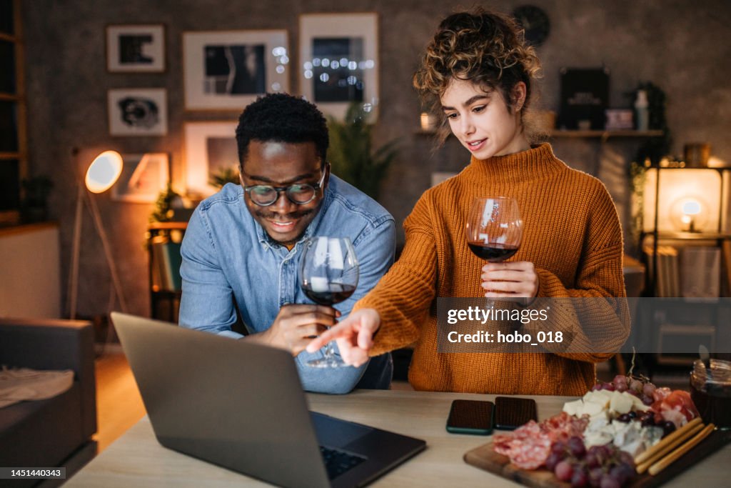 Young couple on a video call with a friends make celebratory toast
