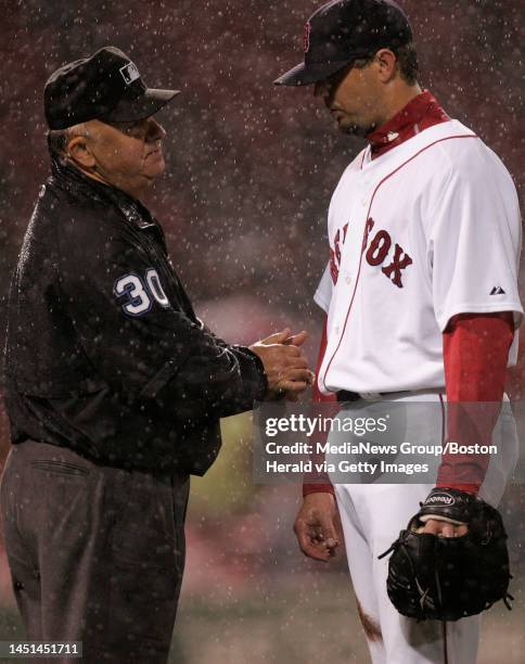 Boston Red Sox pitcher chats with first base umpire Randy Marsh after a rain delay was called in the fifth inning against the Tampa Bay Rays at...