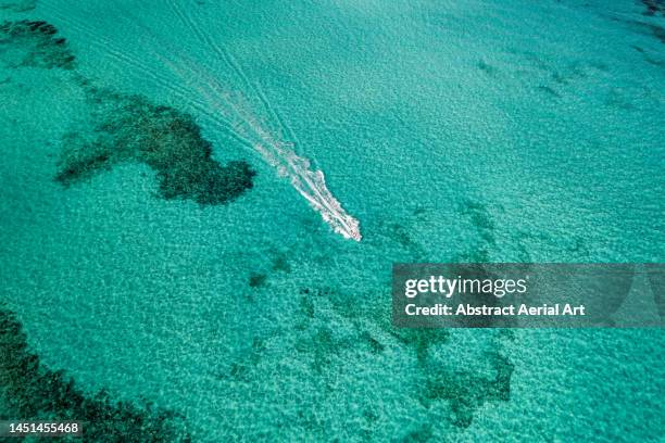 aerial image showing a speed boat off the coast of paradise island, bahamas - bahamas aerial stockfoto's en -beelden
