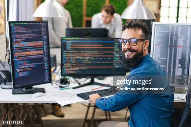 lächelnder it-programmierer, der am desktop-computer arbeitet. männlicher spezialist, der innovative software entwickelt. ingenieur entwicklung von app, programm, videospiel. schreiben von code im terminal - games console infographics stock-fotos und bilder