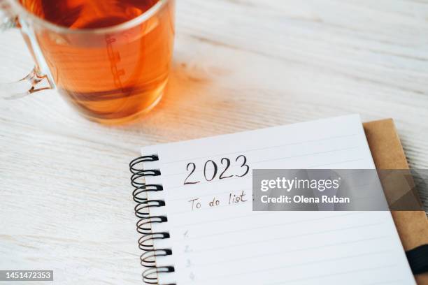 2023 to do list: on notepad and glass of tea. - to do list stock-fotos und bilder