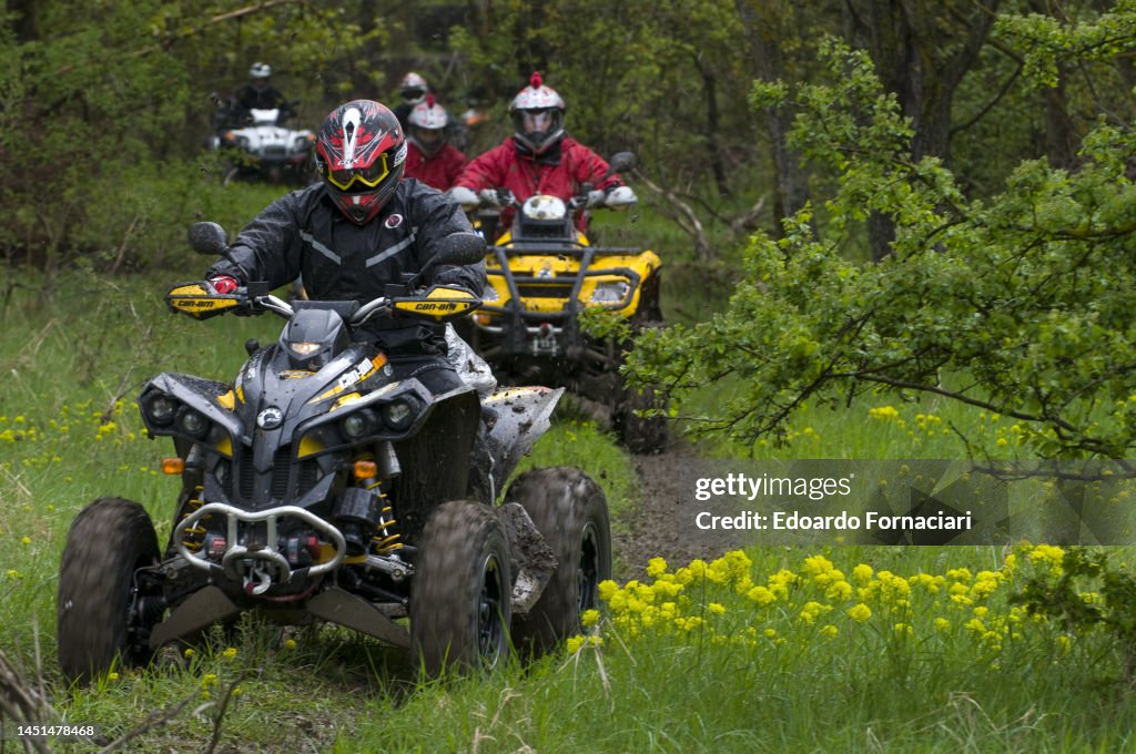 View of competitors as they race quad bikes through field, Val Parma ...
