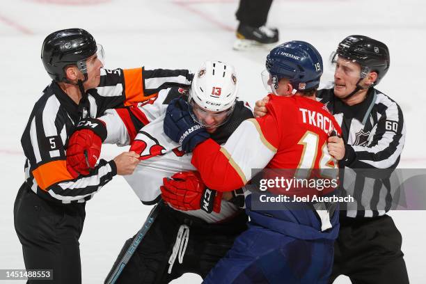 Referee Chris Rooney and Linesman Libor Suchanek break up the fight between Nico Hischier of the New Jersey Devils and Matthew Tkachuk of the Florida...