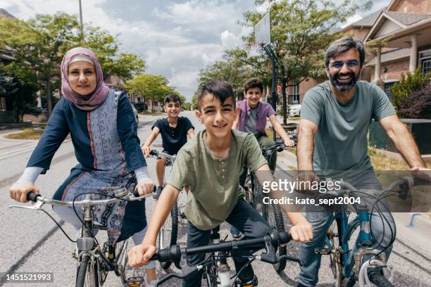 family biking around neighbourhood - family politics stock pictures, royalty-free photos & images