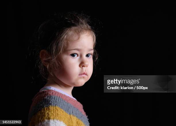 portrait of cute girl against black background,new york,united states,usa - clair obscur stockfoto's en -beelden