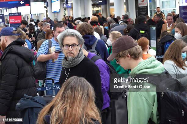 Travelers arrive for flights at O'Hare International Airport on December 22, 2022 in Chicago, Illinois. A winter weather system bringing snow, high...
