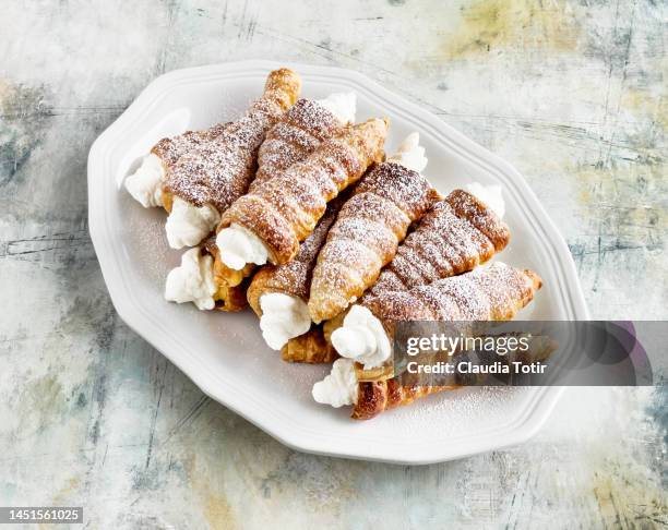 platter of pastry cream horns on multicolored background - stuffed stock pictures, royalty-free photos & images