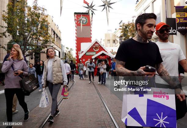 Shoppers walk through The Grove shopping mall during the holiday shopping season, three days before Christmas, on December 22, 2022 in Los Angeles,...