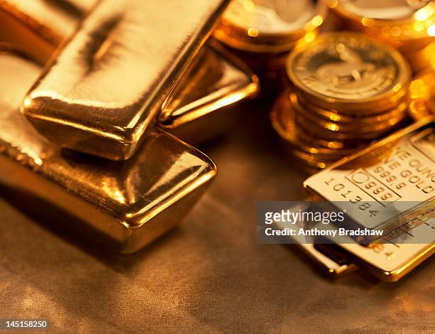 gold ingots and coins close up - gold coin stock-fotos und bilder