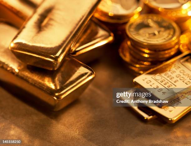 gold ingots and coins close up - gold bullion stockfoto's en -beelden